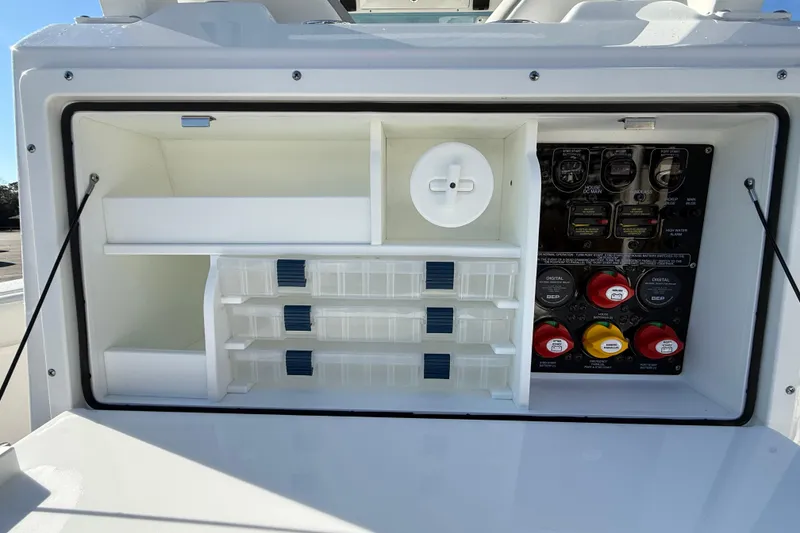 Slide: The Image of 2024 Sea Fox 288 Commander storage compartment with organized shelves and control panel. - 23