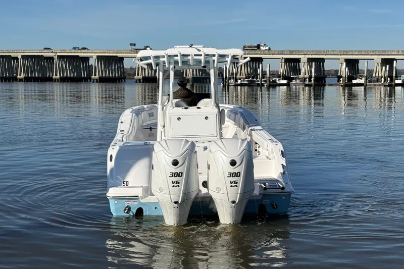 Slide: The Image of 2024 Sea Fox 288 Commander boat with dual engines on calm water near a bridge. - 3