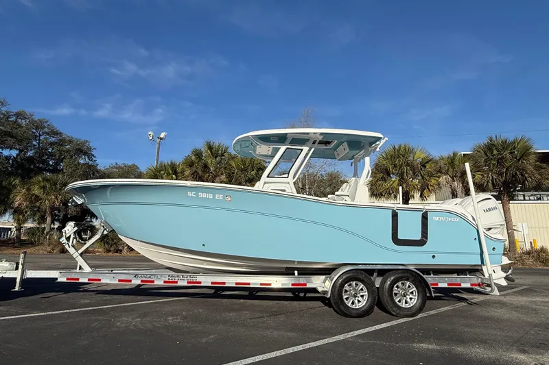 Slide: The Image of 2024 Sea Fox 288 Commander boat on trailer, light blue hull, parked outdoors. - 4