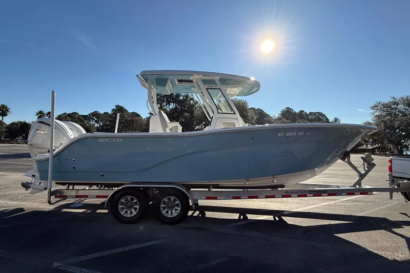 Slide: The Image of 2024 Sea Fox 288 Commander boat on trailer under bright sunlit sky. - 6