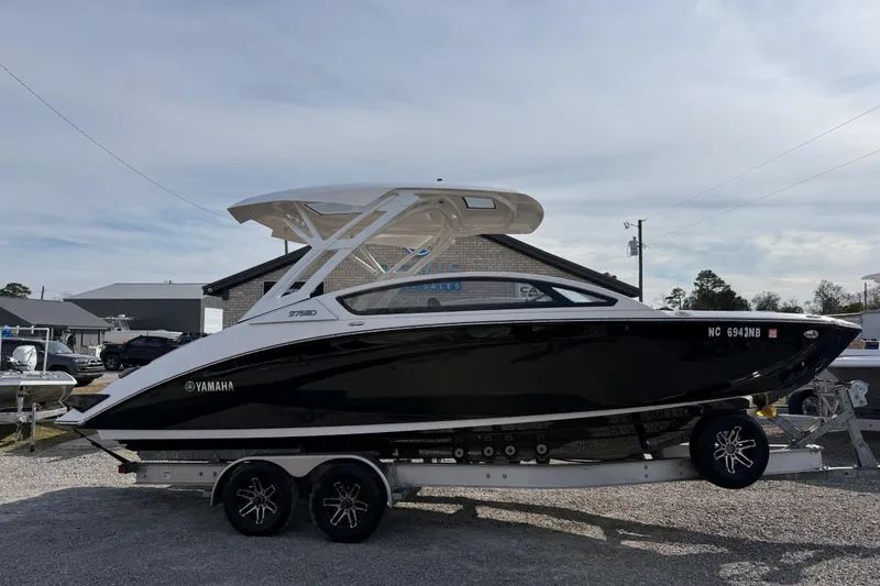 The Image of 2024 Yamaha 275SDX boat on trailer, sleek black design, parked outdoors. - 1
