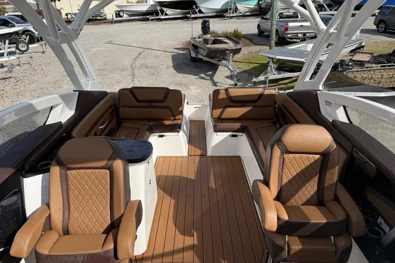 Slide: The Image of 2024 Yamaha 275SDX boat interior with luxurious brown seating and wood flooring. - 12