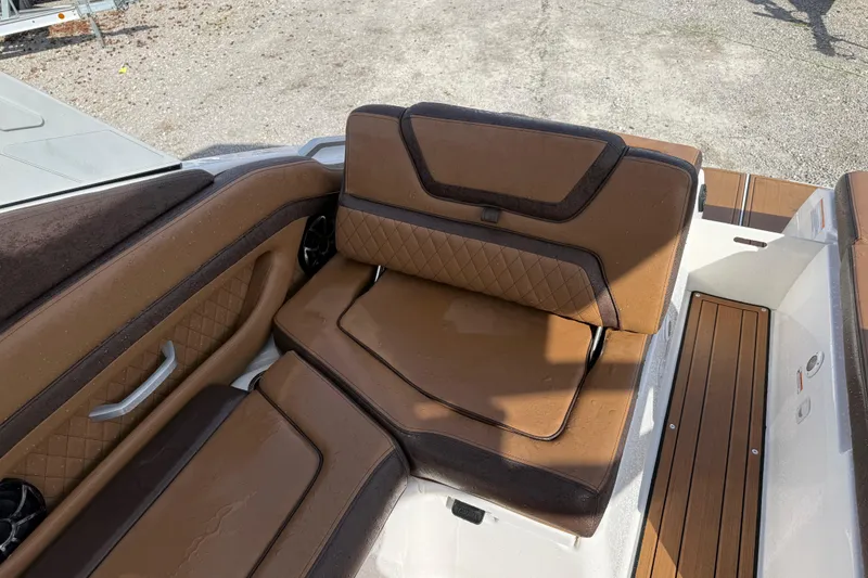 Slide: The Image of 2024 Yamaha 275SDX boat interior with brown leather seating and wood accents. - 17