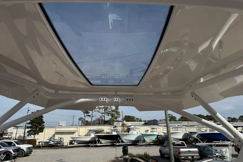 Slide: The Image of 2024 Yamaha 275SDX boat with a sleek glass roof, parked in a marina. - 19