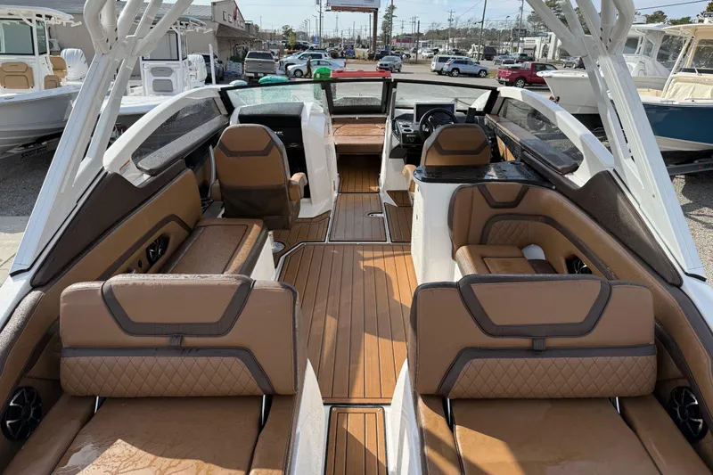 Slide: The Image of 2024 Yamaha 275SDX boat interior with luxurious brown seating and sleek design. - 8