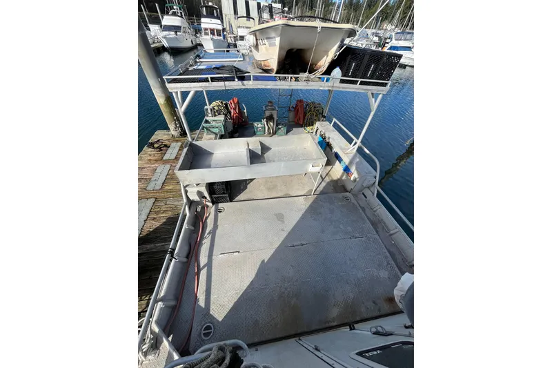 Slide: The Image of 1992 Munson 38’ Aluminum Commercial Dive boat docked, featuring spacious deck and equipment storage. - 8