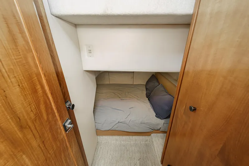 Slide: The Image of 1998 Bayliner 3988 Motoryacht cabin interior with cozy bed and wooden doors. - 14