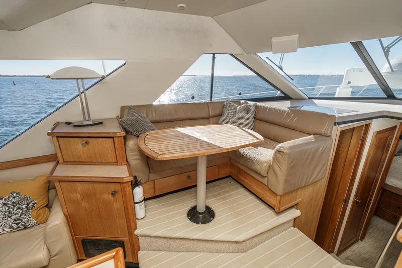 Slide: The Image of 1998 Bayliner 3988 Motoryacht interior with cozy seating and wooden table, overlooking the water. - 21