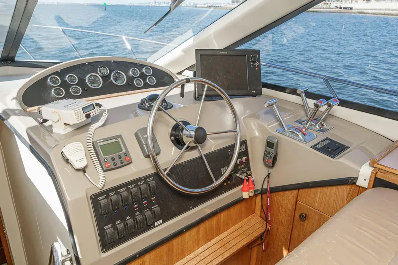 Slide: The Image of 1998 Bayliner 3988 Motoryacht helm with steering wheel, controls, and navigation equipment. - 25