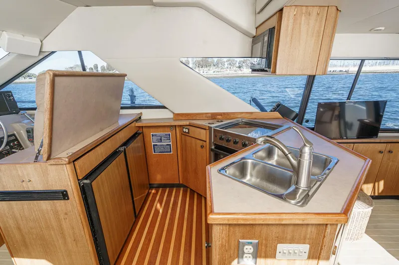 Slide: The Image of 1998 Bayliner 3988 Motoryacht kitchen with wood cabinetry, stainless steel sink, and ocean view. - 33