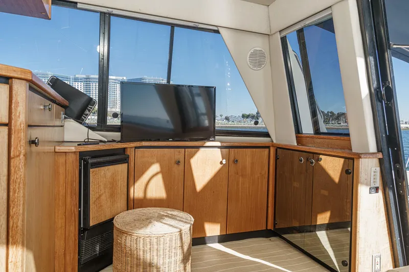 Slide: The Image of Interior of 1998 Bayliner 3988 Motoryacht with TV, wicker stool, and wooden cabinetry. - 36