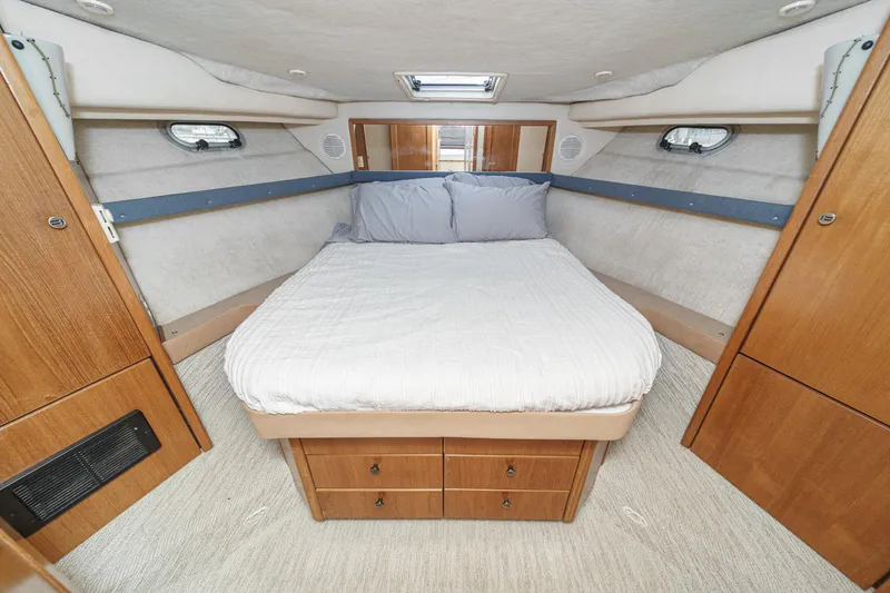 Slide: The Image of 1998 Bayliner 3988 Motoryacht bedroom with cozy bed and wooden cabinetry. - 4