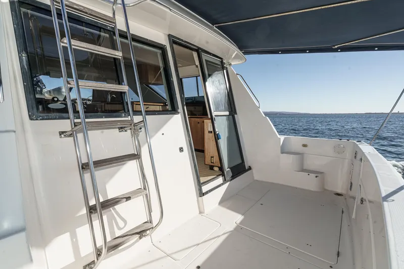 Slide: The Image of 1998 Bayliner 3988 Motoryacht deck with ladder, open door, and ocean view. - 47
