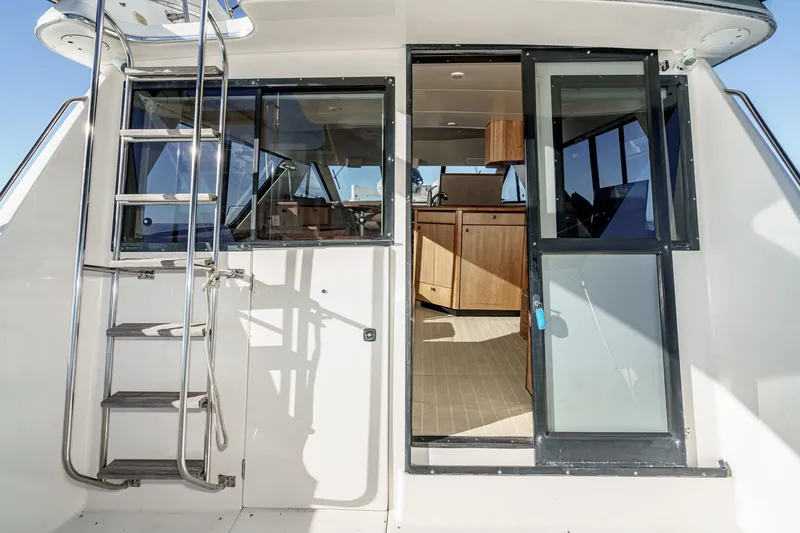 Slide: The Image of 1998 Bayliner 3988 Motoryacht with open cabin door and exterior ladder. - 48