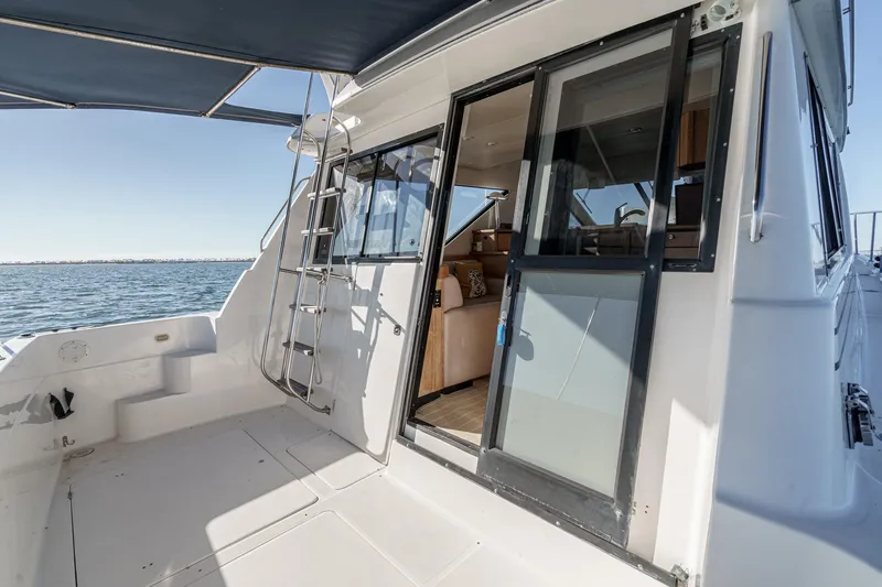 Slide: The Image of 1998 Bayliner 3988 Motoryacht with open cabin door, ocean view, and ladder. - 5