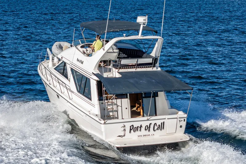 Slide: The Image of 1998 Bayliner 3988 Motoryacht cruising on open water, rear view. - 50