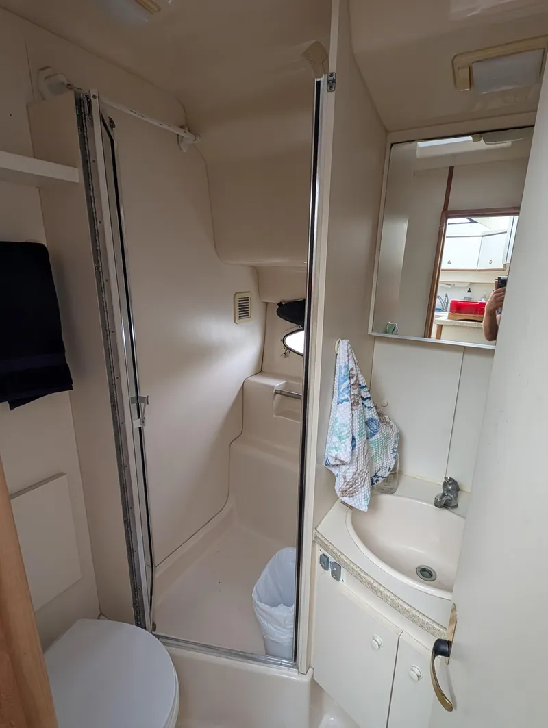 Slide: The Image of 1999 Silverton 351 Sedan Cruiser bathroom with shower, sink, and mirror. - 8