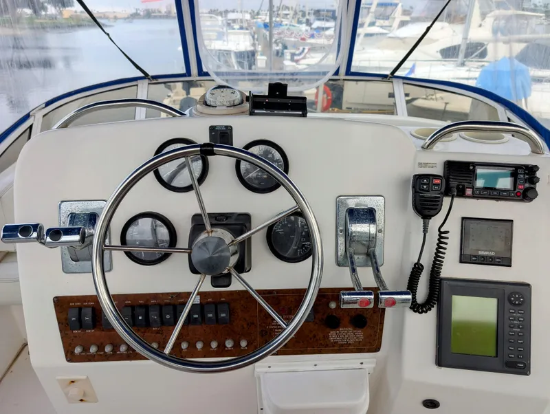 Slide: The Image of 1999 Silverton 351 Sedan Cruiser helm with steering wheel, gauges, and navigation equipment. - 9