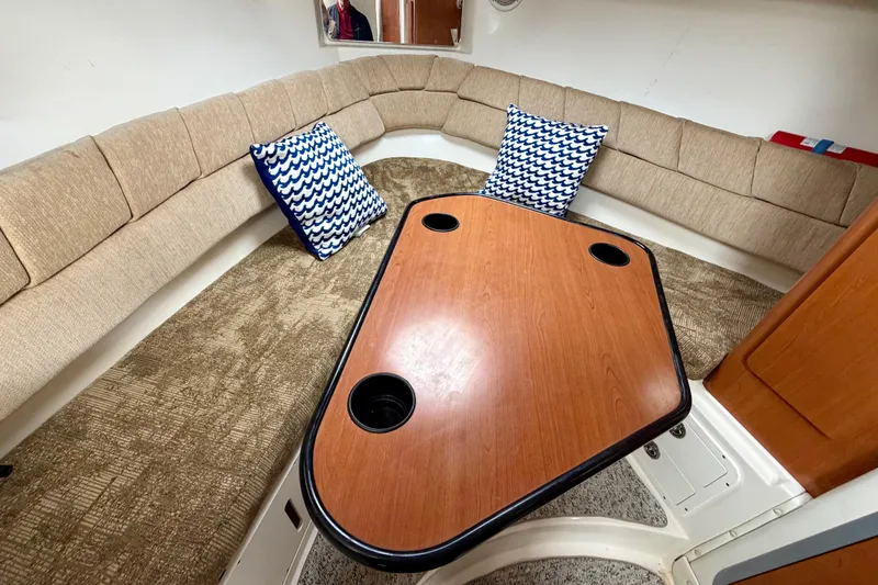 Slide: The Image of 2006 Seaswirl Striper 2901 Walkaround O/B cabin with cushioned seating and wooden table. - 16