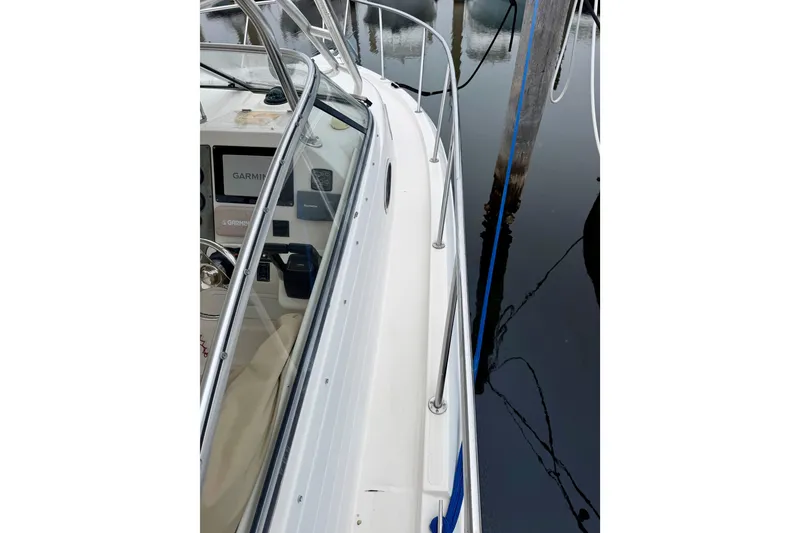 Slide: The Image of 2006 Seaswirl Striper 2901 Walkaround O/B boat docked, showing side railing and cockpit. - 19