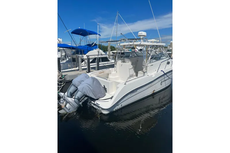 Slide: The Image of 2006 Seaswirl Striper 2901 Walkaround O/B docked, featuring dual outboard motors. - 8