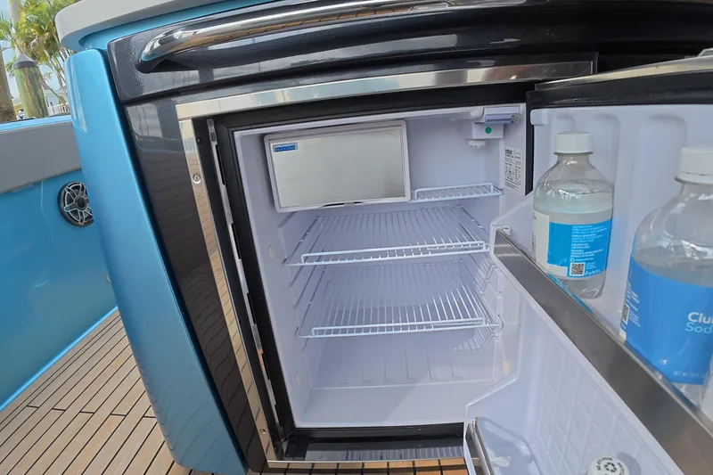 Slide: The Image of Open mini fridge on Schaefer V44 yacht, showcasing interior shelves and bottled drinks. - 24