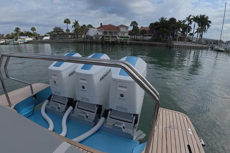 Slide: The Image of Schaefer V44 2025 yacht with triple Mercury outboard engines, docked by a scenic waterfront. - 26