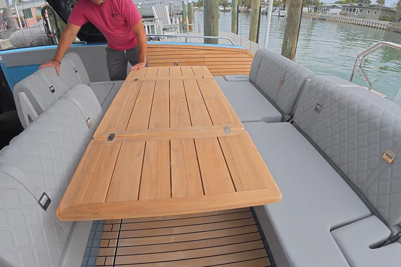 Slide: The Image of 2025 Schaefer V44 yacht interior with wooden table and cushioned seating. - 33