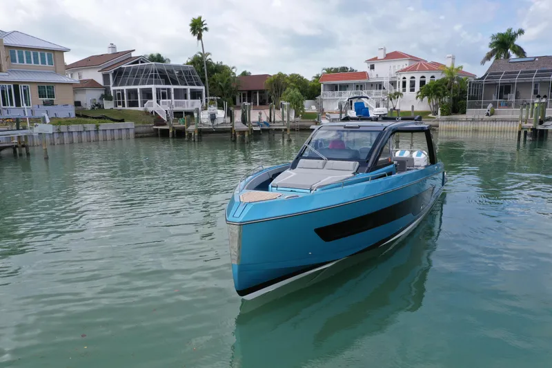 Slide: The Image of 2025 Schaefer V44 yacht in a serene waterfront setting with luxury homes. - 36
