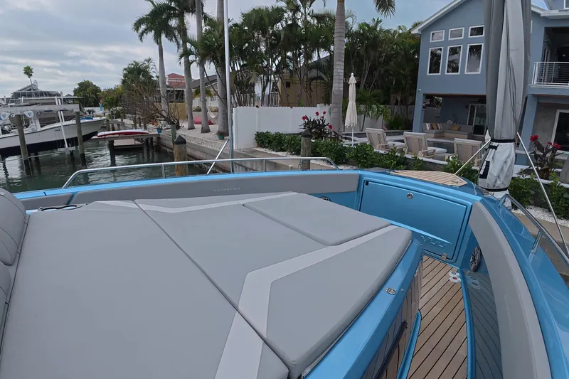 Slide: The Image of 2025 Schaefer V44 yacht docked near waterfront home with lush greenery. - 7