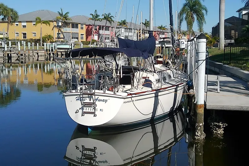 Slide: The Image of 1988 Pearson 36-2 sailboat docked in a sunny marina with palm trees. - 2