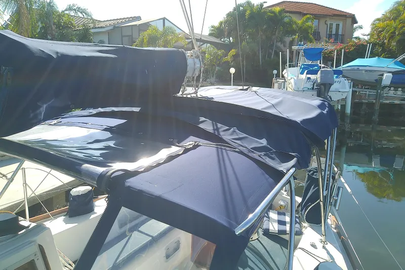Slide: The Image of 1988 Pearson 36-2 sailboat with blue canvas cover docked in sunny marina. - 28