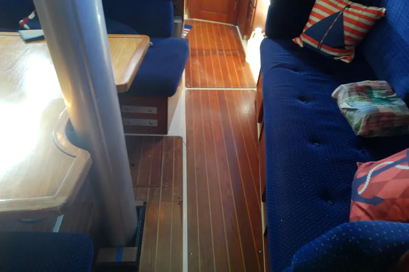 Slide: The Image of Interior of 1988 Pearson 36-2 sailboat with wooden flooring and blue cushioned seating. - 41