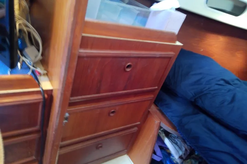Slide: The Image of Interior of 1988 Pearson 36-2 sailboat with wooden drawers and blue bedding. - 44