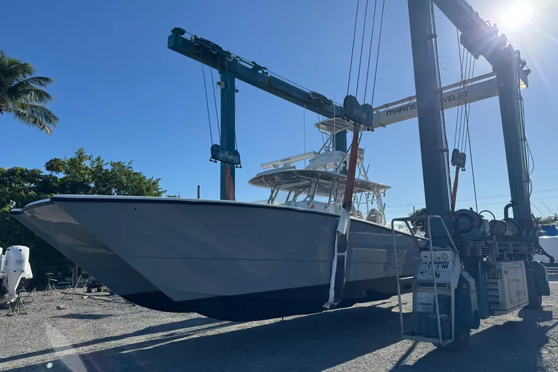 Slide: The Image of 2024 Freeman 42 boat in a marina lift under clear blue sky. - 6