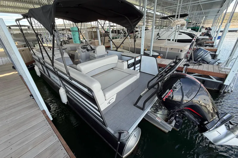The Image of 2022 Crest Classic DLX 220 SLS pontoon boat docked with canopy and Mercury engine. - 1