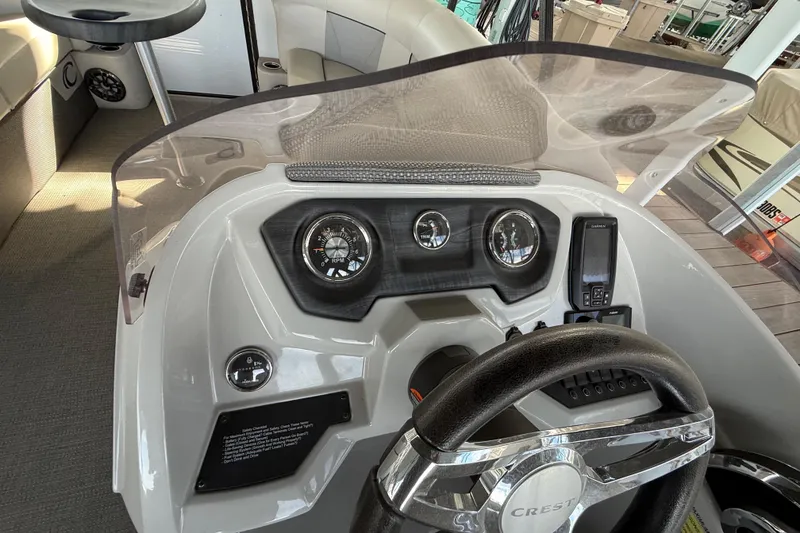 Slide: The Image of 2022 Crest Classic DLX 220 SLS boat dashboard with steering wheel and gauges. - 14