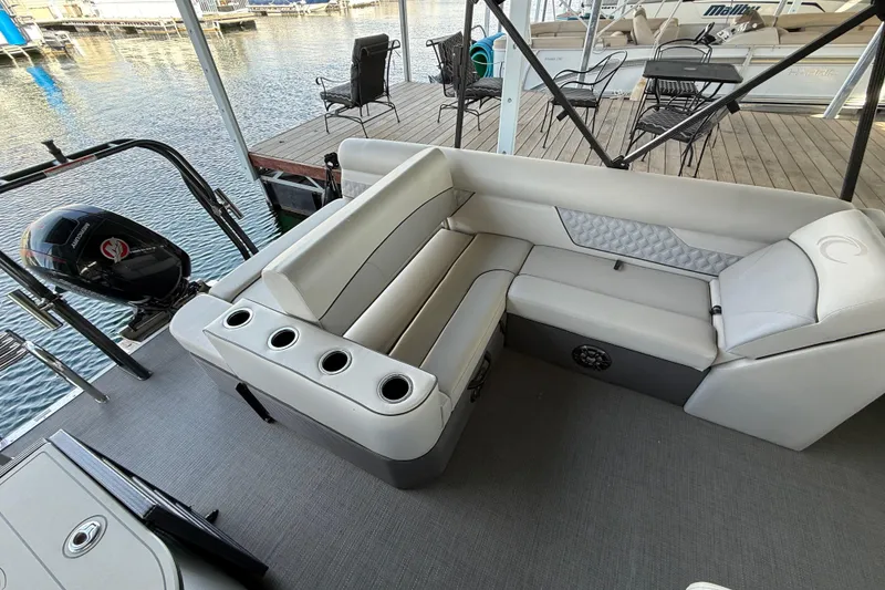 Slide: The Image of 2022 Crest Classic DLX 220 SLS pontoon boat interior with seating and outboard motor. - 7