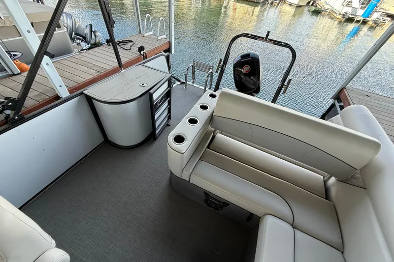 Slide: The Image of 2022 Crest Classic DLX 220 SLS pontoon boat interior with seating and storage. - 8