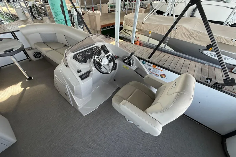 Slide: The Image of 2022 Crest Classic DLX 220 SLS boat interior with helm and seating area. - 9