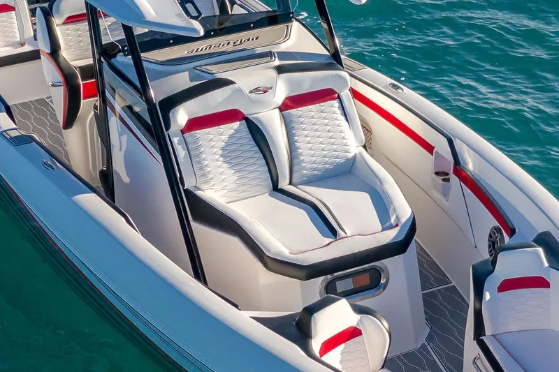 Slide: The Image of 2022 Sunsation 32 CCX boat interior with white and red seating, parked outdoors. - 13