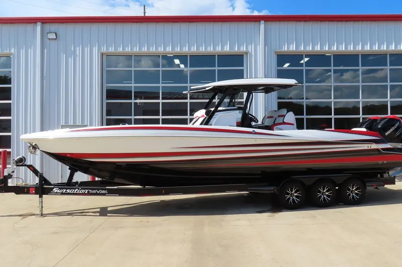 Slide: The Image of 2022 Sunsation 32 CCX boat with red and white design on a trailer. - 2