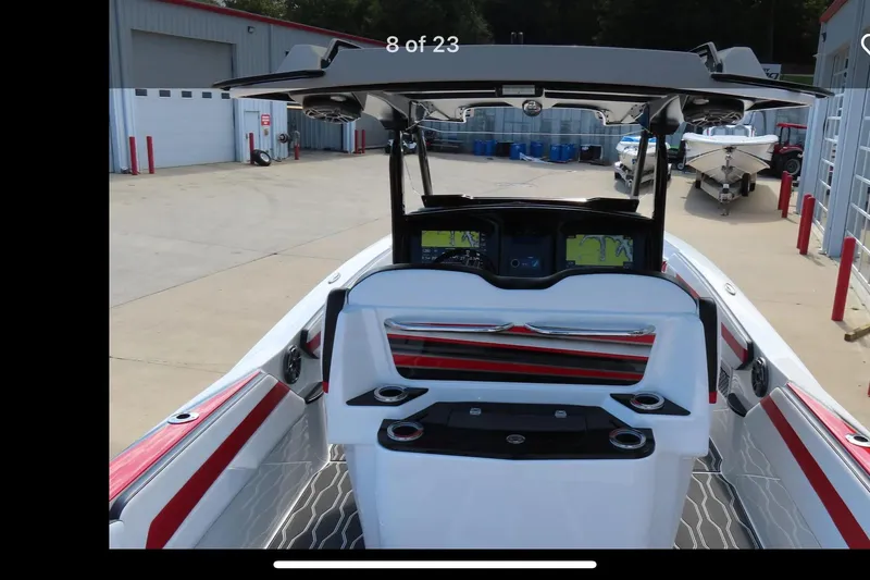 Slide: The Image of 2022 Sunsation 32 CCX boat with sleek interior and modern design in a driveway setting. - 7