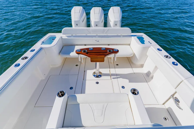 Slide: The Image of 2025 SeaVee 370Z boat deck with triple Mercury engines, fishing rod holders, and storage compartments. - 26