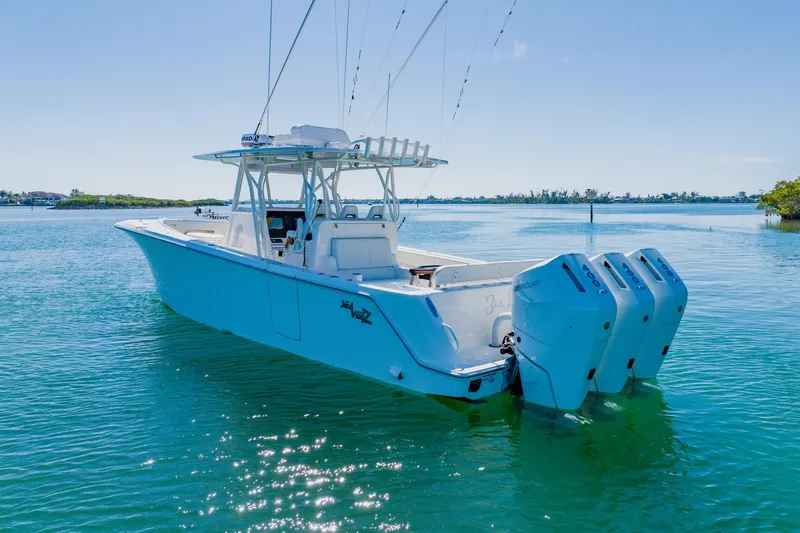 Slide: The Image of Aerial view of 2025 SeaVee 370Z boat with triple outboard engines on clear water. - 3