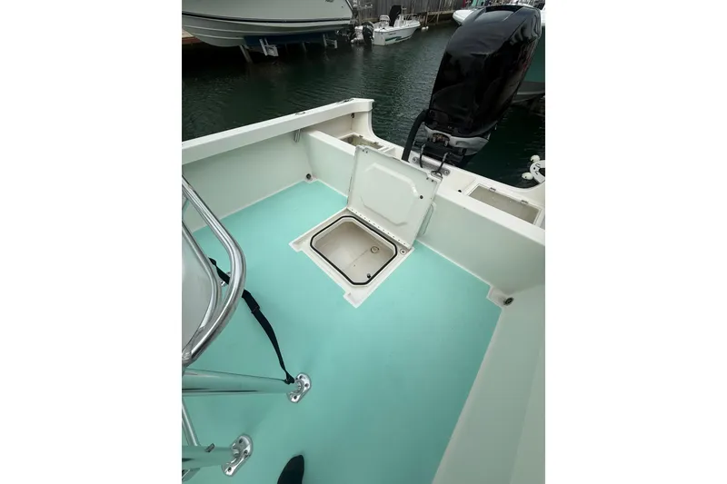 Slide: The Image of 2015 Albury Brothers 23 Center Console boat with open storage compartment, docked in marina. - 15