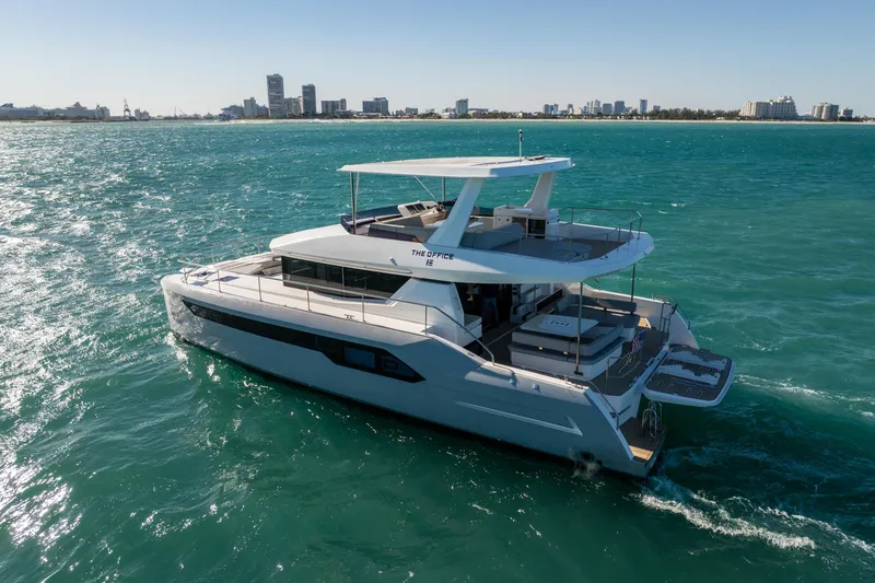 Slide: The Image of 2021 Leopard 53 Powercat yacht cruising on turquoise waters near a city skyline. - 10