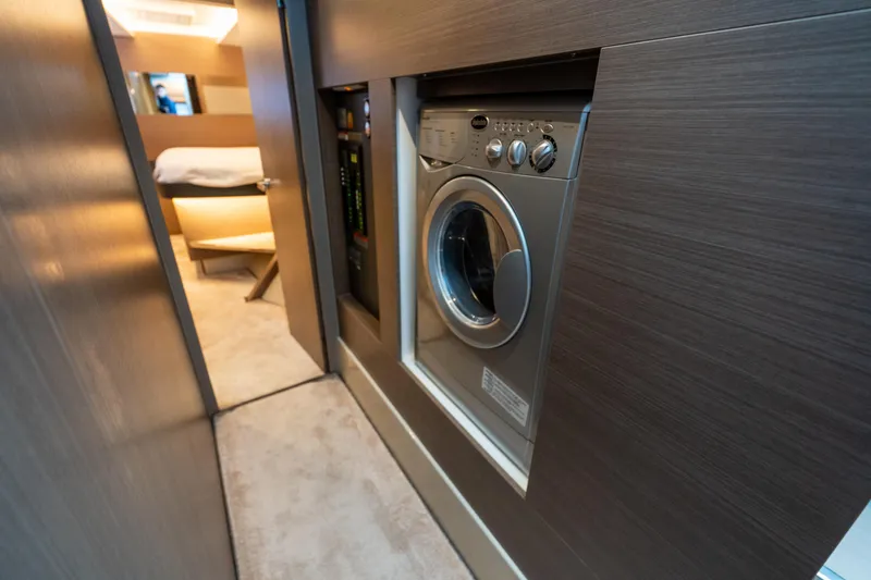 Slide: The Image of Laundry area inside 2021 Leopard 53 Powercat yacht, featuring modern washing machine. - 24