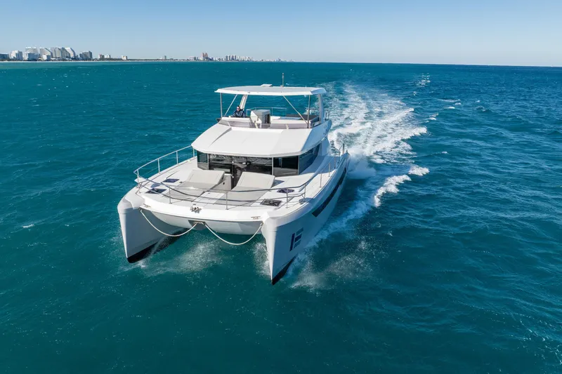 Slide: The Image of 2021 Leopard 53 Powercat cruising on open blue ocean near city skyline. - 5