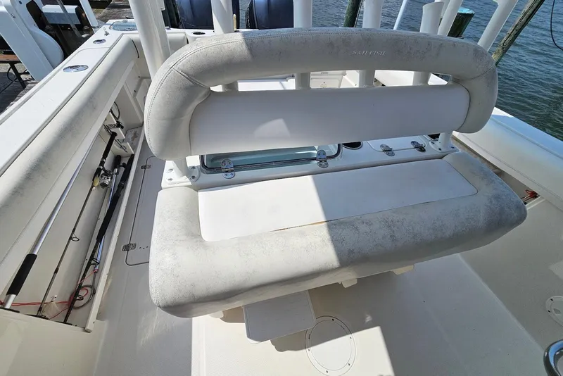 Slide: The Image of 2014 Sailfish 290 CC boat interior with cushioned seating and fishing rod holders. - 10
